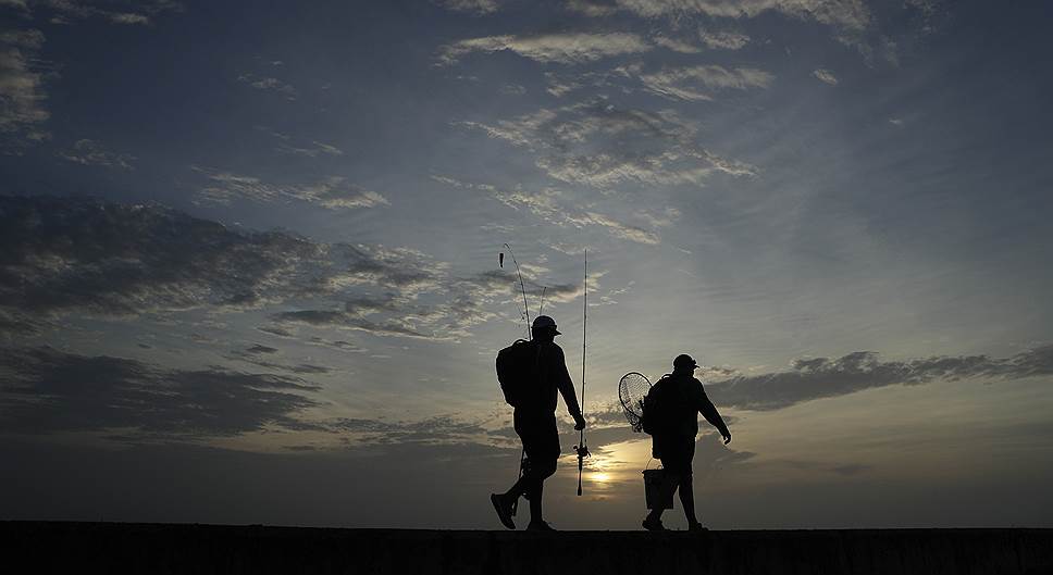 Техас, США. Рыбаки идут вдоль причала на рассвете