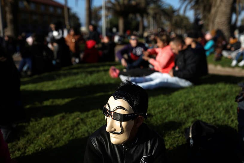 Ла-Серена, Чили. Человек в очках поверх маски наблюдают солнечное затмение 