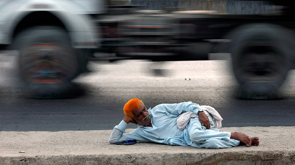 Карачи, Пакистан. Мужчина отдыхает на дороге в припортовом районе