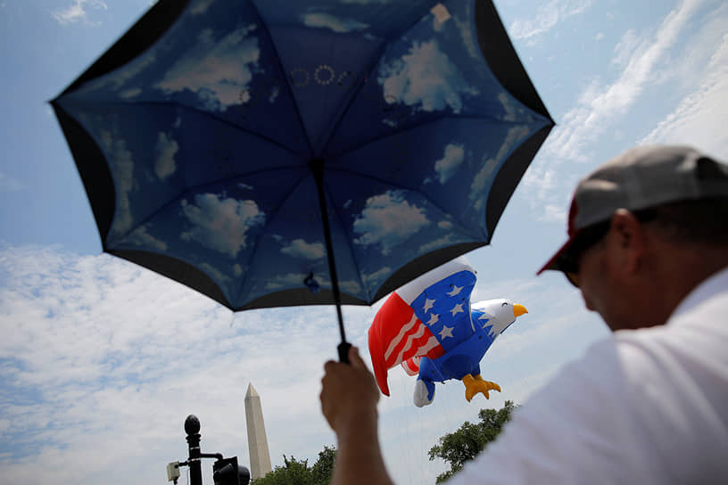 Вашингтон, округ Колумбия. Мужчина с зонтиком на параде в честь Дня независимости