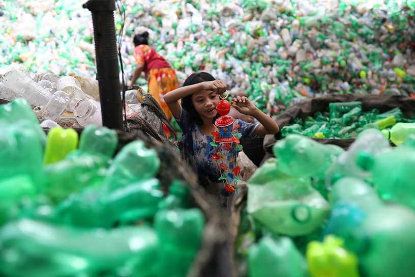 Дакка, Бангладеш. Девочка с игрушкой, найденной на заводе по переработке пластмассы