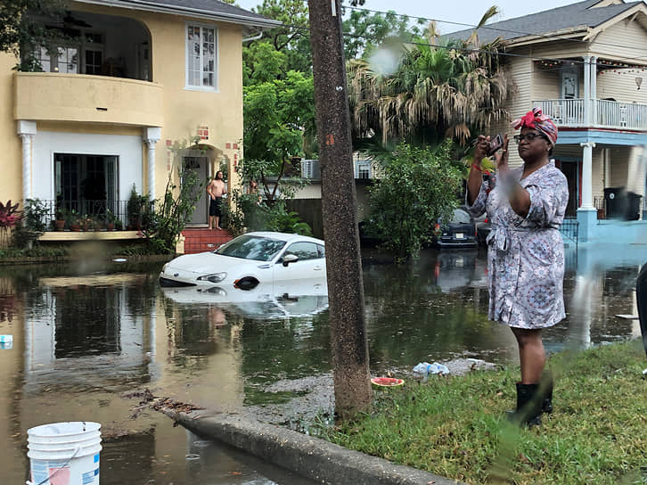 Новый Орлеан, США. Местная жительница фотографирует затопленную во время сильного дождя улицу