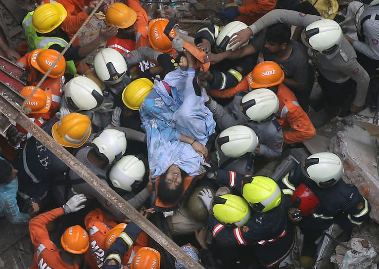 Мумбаи, Индия. Спасатели выносят пострадавших во время обрушения жилого здания 