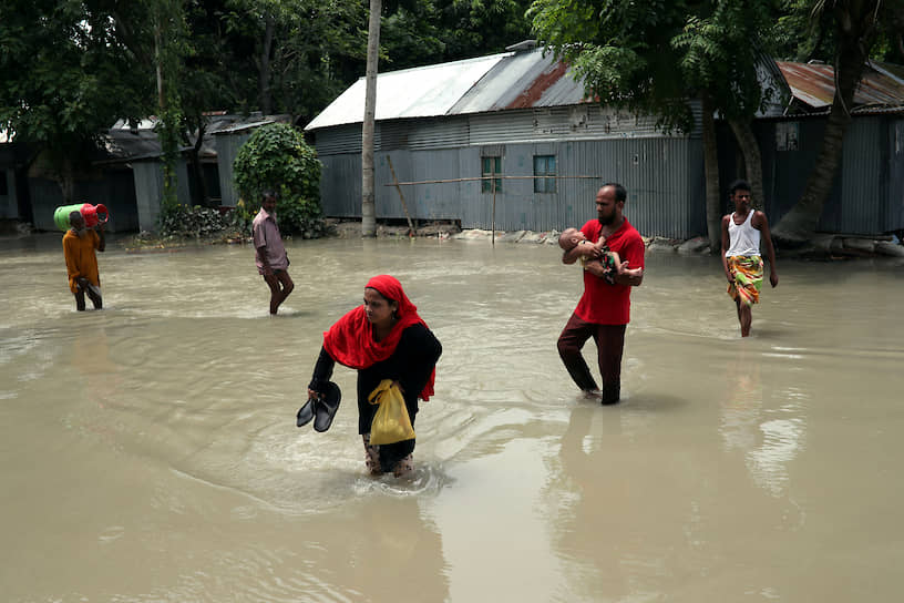 Джамалпур, Бангладеш. Местные жители пересекают затопленную дорогу