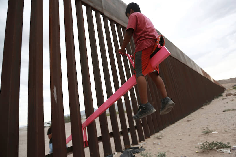 Сьюдад-Хуарес, Мексика. Качели, установленные в заборе на границе Мексики и США