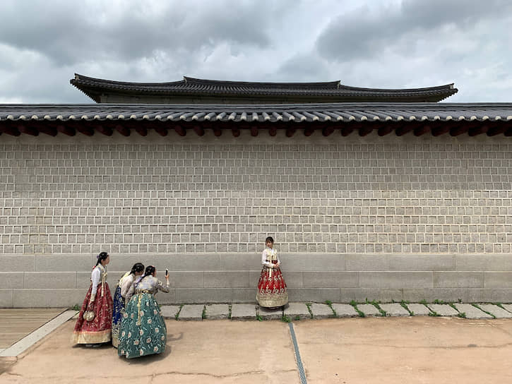 Сеул, Южная Корея. Туристы фотографируются в национальных костюмах у императорского дворца