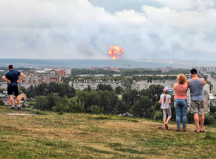 Ачинский район, Красноярский край, Россия. Люди смотрят на пожар, возникший на военном складе 