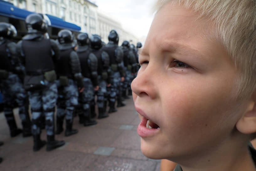 Санкт-Петербург, Россия. Мальчик смотрит на полицейское оцепление во время одиночных пикетов в поддержку московского митинга «За свободные выборы» на Невском проспекте