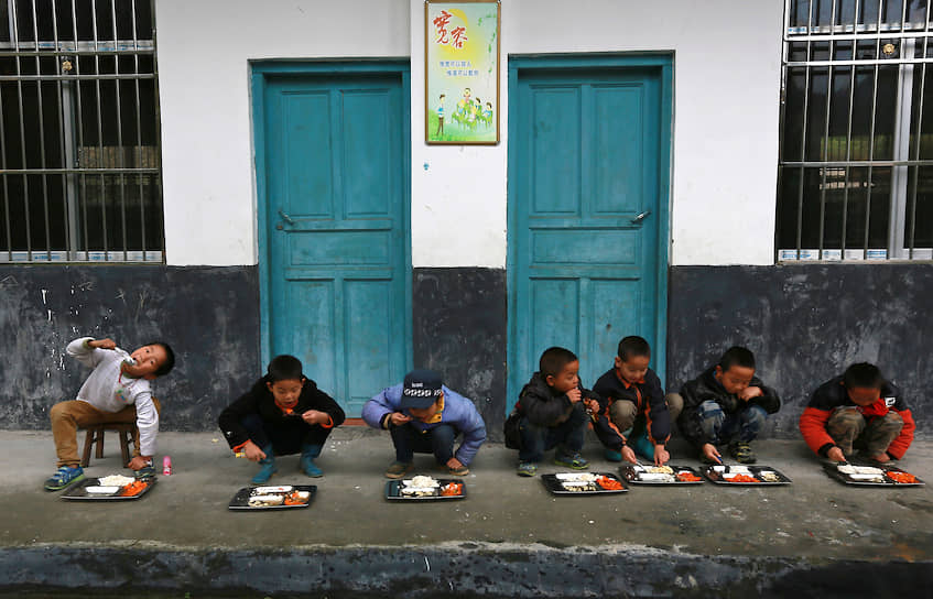 Ученики обедают возле здания школы, город Дунгуань 