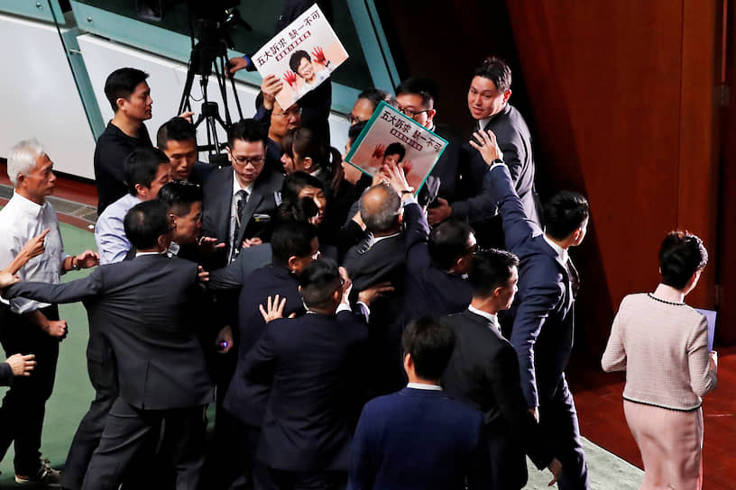 Гонконг. Глава администрации Гонконга Кэрри Лам (справа) покидает парламент из-за протестов ряда законодателей 