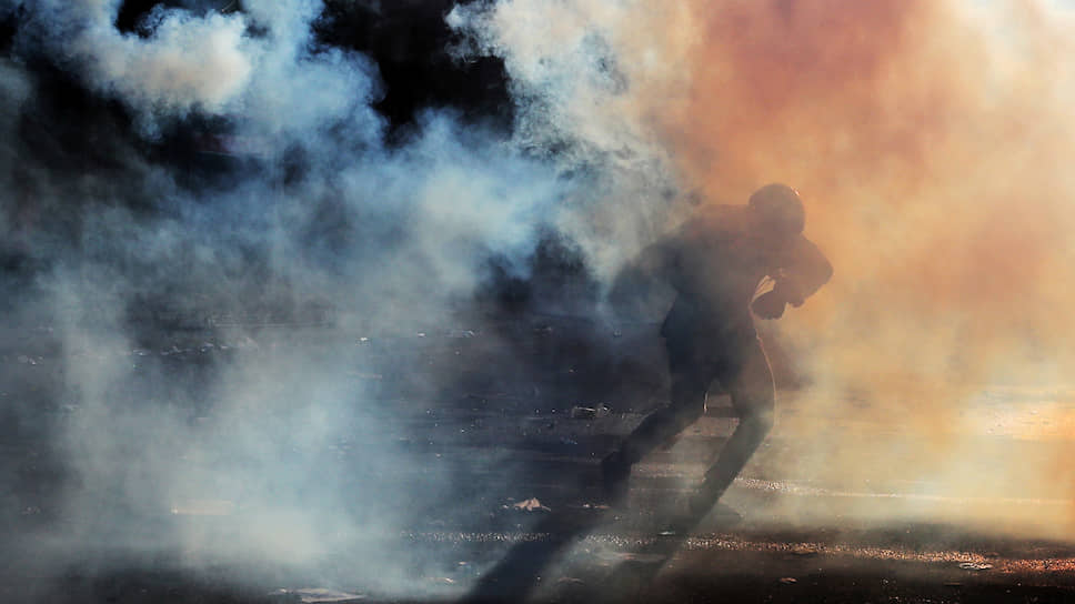 Сантьяго, Чили. Демонстрант спасается от слезоточивого газа во время антиправительственных протестов