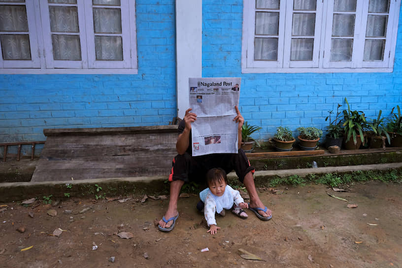 Кохима, штат Нагаленд, Индия. Мужчина читает газету со статьей о переговорах с правительством страны насчет введения флага и конституции Нагаленда