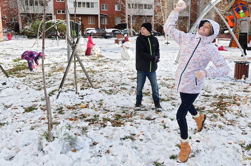 Санкт-Петербург, Россия. Дети играют в снежки на детской площадке