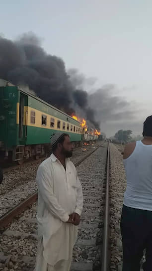 Рахим Яр Хан, Пакистан. Мужчины стоят возле горящего поезда