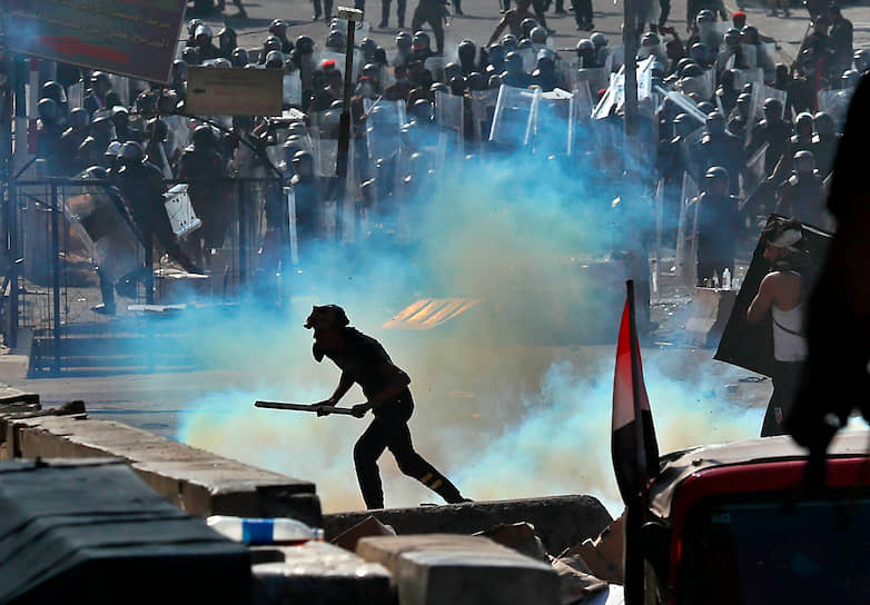 Багдад, Ирак. Полицейские стреляют слезоточивым газом в  протестующих против правительства демонстрантов