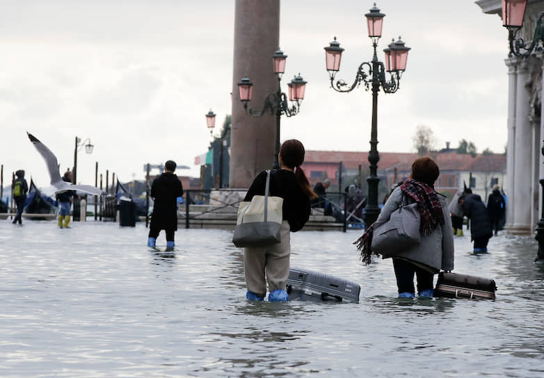 Венеция, Италия. Туристы во время наводнения в центре города