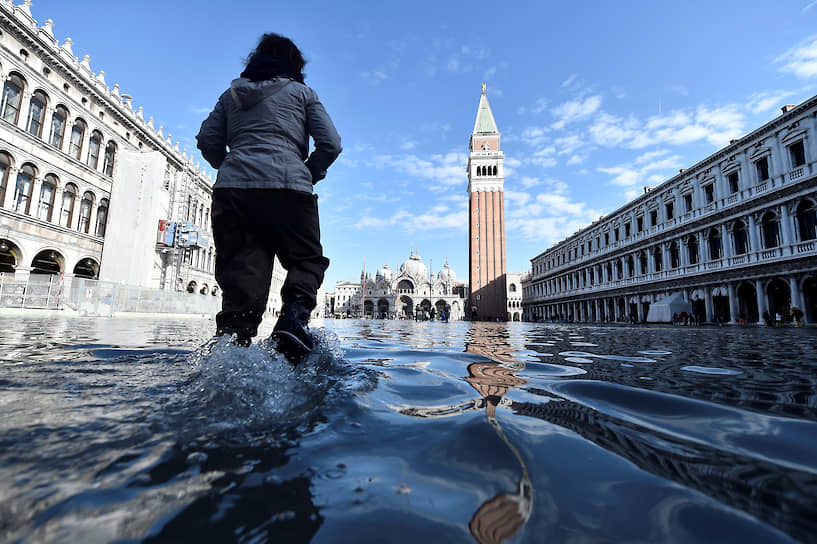 Венеция, Италия. Женщина гуляет по центру города во время наводнения