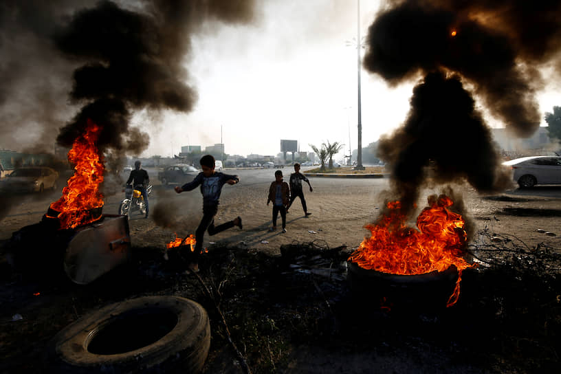 Эн-Наджеф, Ирак. Мальчики возле горящих шин во время акций протеста
