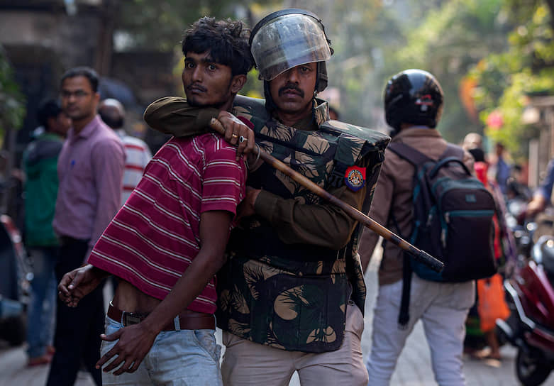 Гувахати, Индия. Полицейский удерживает демонстранта во время акций протеста