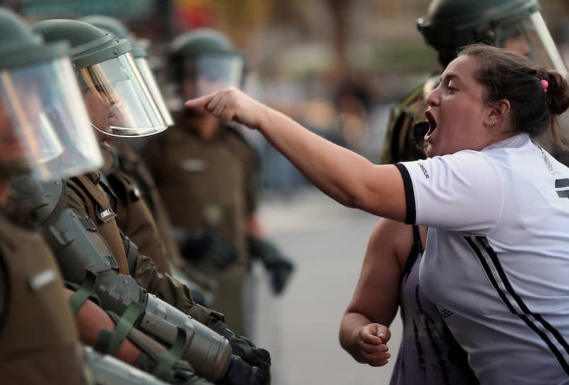 Сантьяго, Чили. Женщина спорит с полицейским во время антиправительственной акции протеста