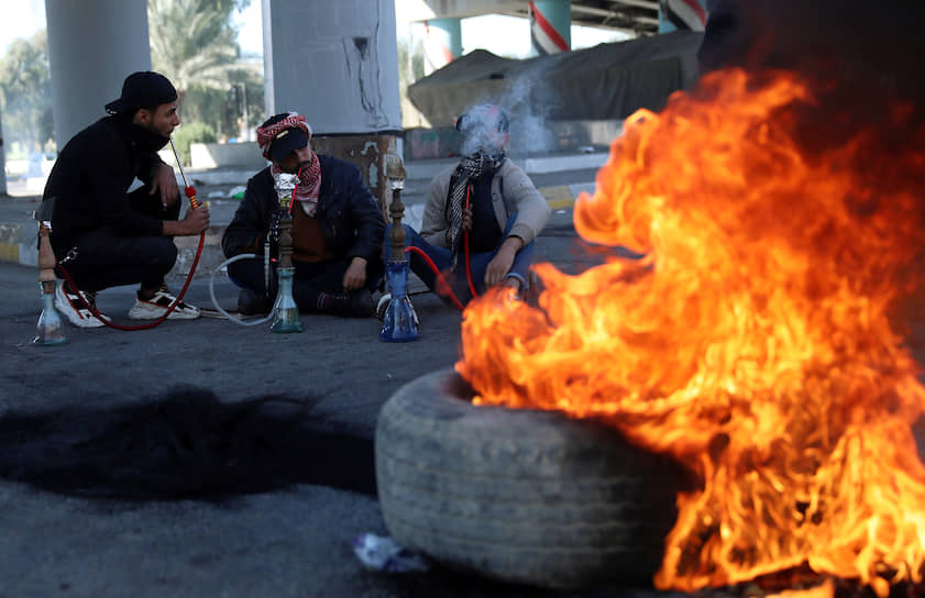 Кербела, Ирак. Демонстранты жгут шины и курят кальян во время акции протеста
