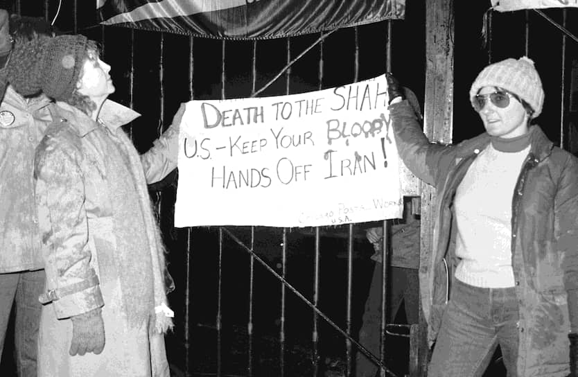 Две американки из группы, которая поддерживала захват посольства, у ворот дипмиссии с плакатом: «Смерть шаху! США убери свои кровавые руки от Ирана!»