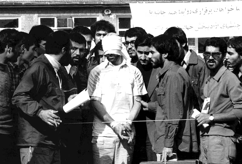 Иранские студенты показывают одного из заложников иностранным СМИ. Им было важно донести до международной общественности, почему они решились на захват посольства: «Мы верили, что имеем на это право – что, если мы не нападем на посольство, они могут напасть на нас». (11 ноября 1979 года)