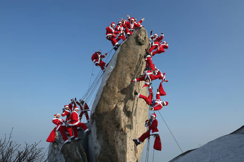 Сеул, Южная Корея. Альпинисты в костюмах Санта-Клауса поднимаются на гору Бакхан   