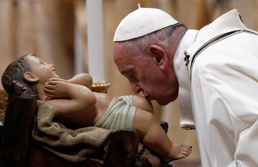 Собор Святого Петра, Ватикан. Папа римский Франциск целует фигурку младенца Иисуса во время службы в сочельник 