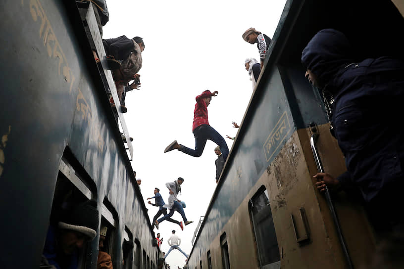 Тонги, Бангладеш. Люди прыгают с поезда на поезд по пути на съезд мусульман 