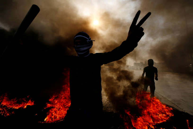 Эн-Наджеф, Ирак. Участники антиправительственной акции протеста среди горящих шин
