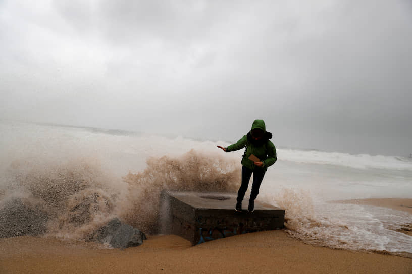 Бадалона, Испания. Женщина фотографируется у моря во время шторма