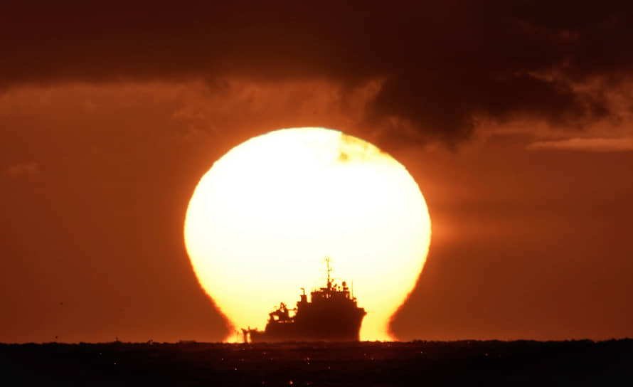 Нортумберленд, Великобритания. Корабль на фоне восходящего солнца