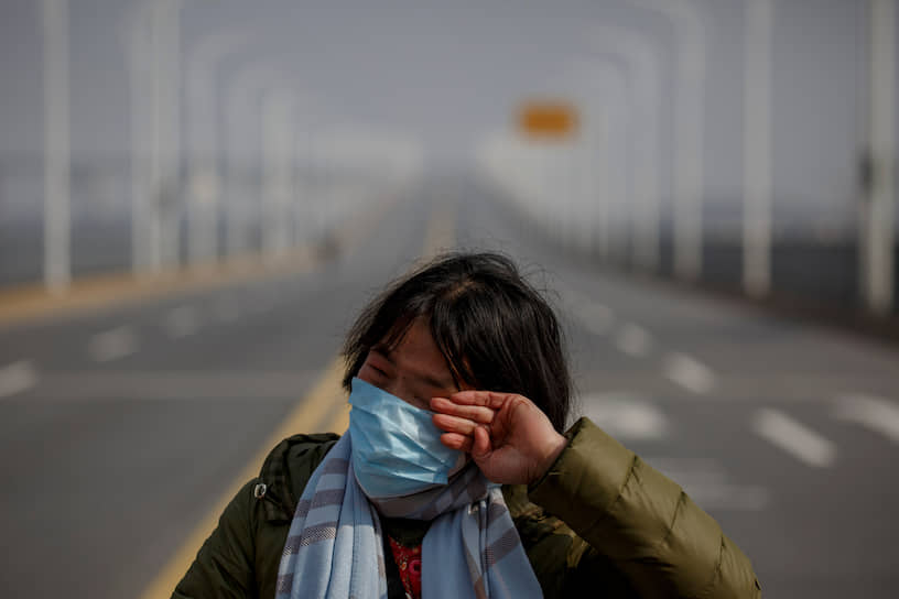 От вируса погибли более 2,2 тыс. человек
&lt;br>
На фото: женщина из наиболее зараженной провинции Хубэй на КПП, ведущем в соседнюю провинцию Цзянси 