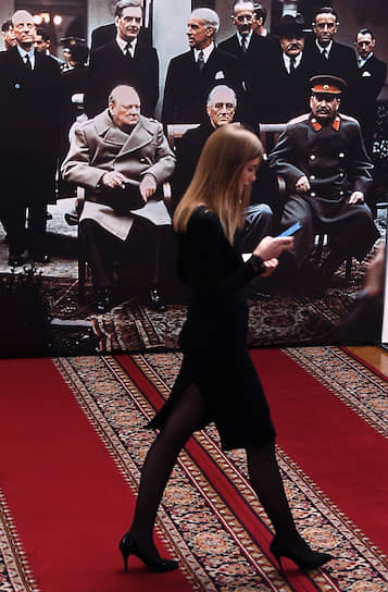 Москва, Россия. Девушка идет в здании Госдумы на фоне фотографии участников Ялтинской конференции 1945 года