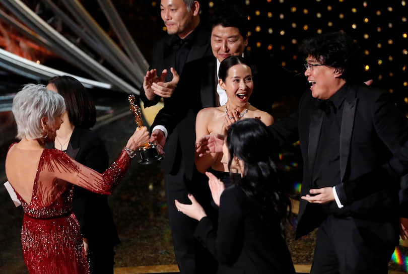 Режиссер Пон Чун Хо (справа) со съемочной группой фильма «Паразиты» получают «Оскар» из рук актрисы Джейн Фонды