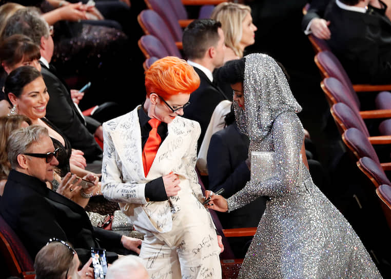 Голливуд, Лос-Анджелес, США. Певица и актриса Жанэль Монэ расписывается на костюме художницы Сэнди Пауэлл на церемонии вручения «Оскаров»