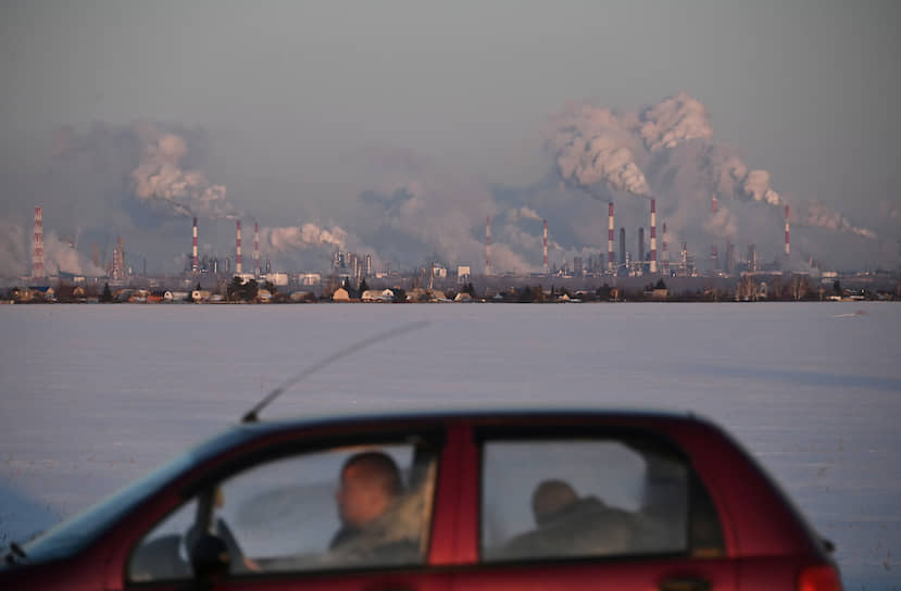 Омск, Россия. Машина едет по дороге недалеко от нефтеперерабатывающего завода