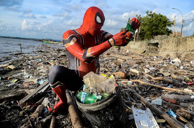 Паре-Паре, Индонезия. Мужчина в костюме Человека-паука собирает мусор на пляже