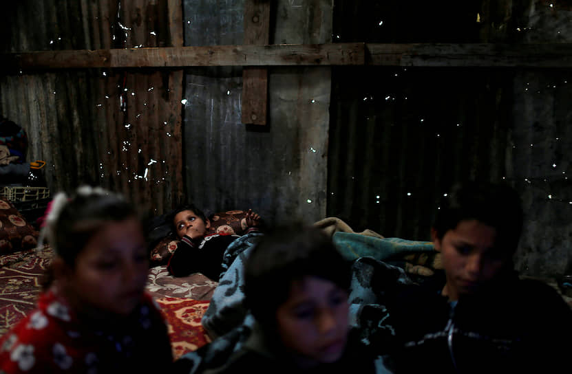 Сектор Газа. Палестинская семья прячется от дождя в своем доме