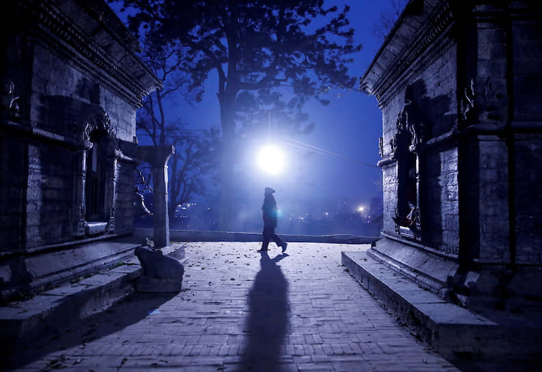 Катманду, Непал. Верующий прогуливается возле храма накануне индуистского праздника