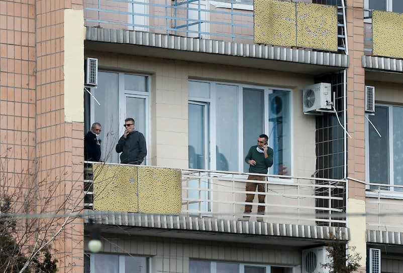 Люди стоят на балконе медицинского центра Национальной гвардии Украины «Новые Санжары»