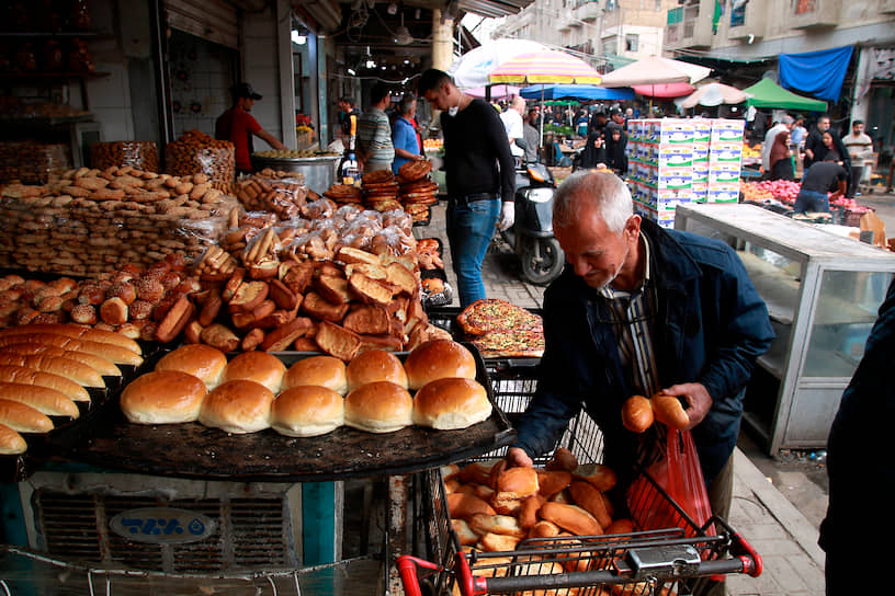 Багдад, Ирак. Местные жители покупают хлеб на рынке в центре города  
