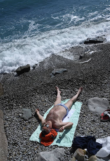 Ялта, Крым, Россия. Отдыхающий мужчина на пляже  