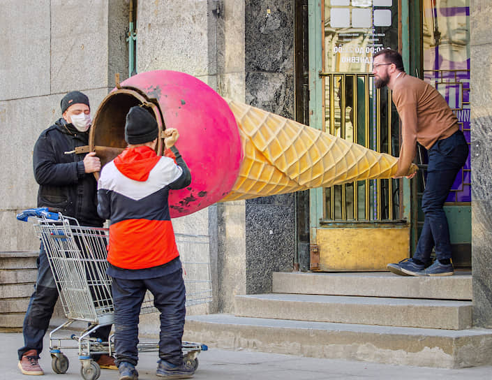Москва. Рекламный стенд в виде мороженого заносят в здание кафе