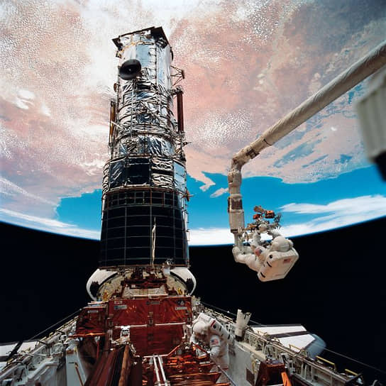 Астронавты в открытом космосе во время технического обслуживания космического телескопа Hubble