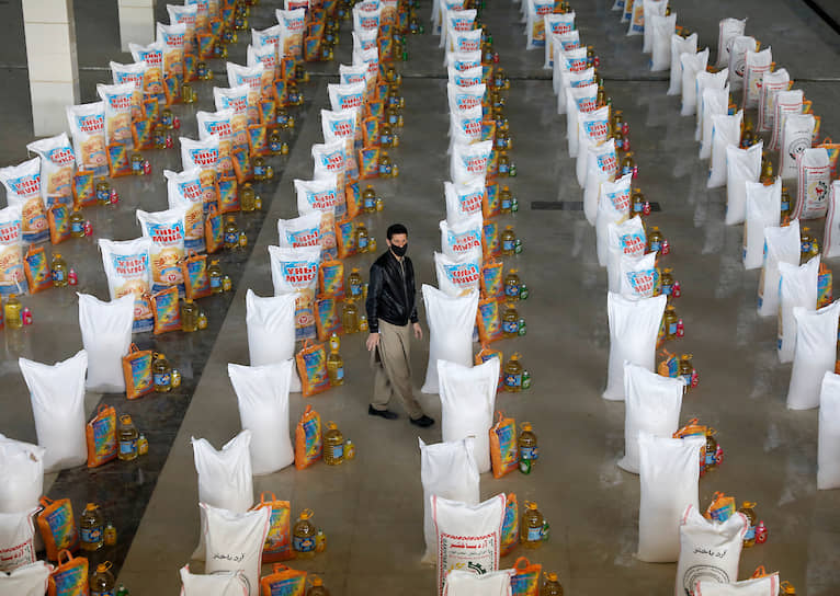 Кабул, Афганистан. Мужчина стоит у пакетов с едой, пожертвованной нуждающимся 