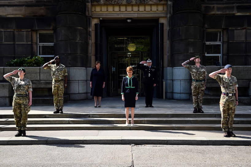 Эдинбург, Великобритания. Первый министр Шотландии Никола Стерджен (в центре) во время минуты молчания