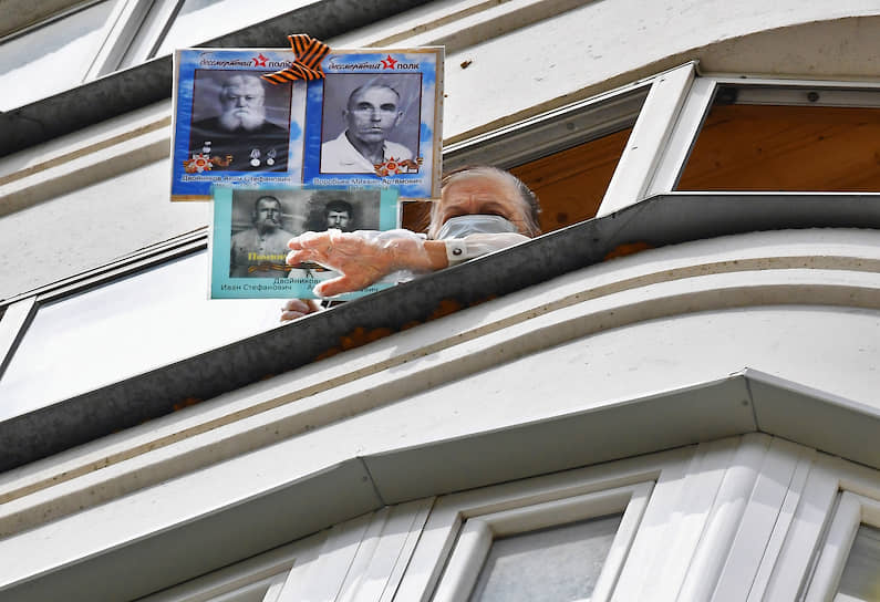 Москва. Женщина на балконе с портретами участников Великой Отечественной войны 