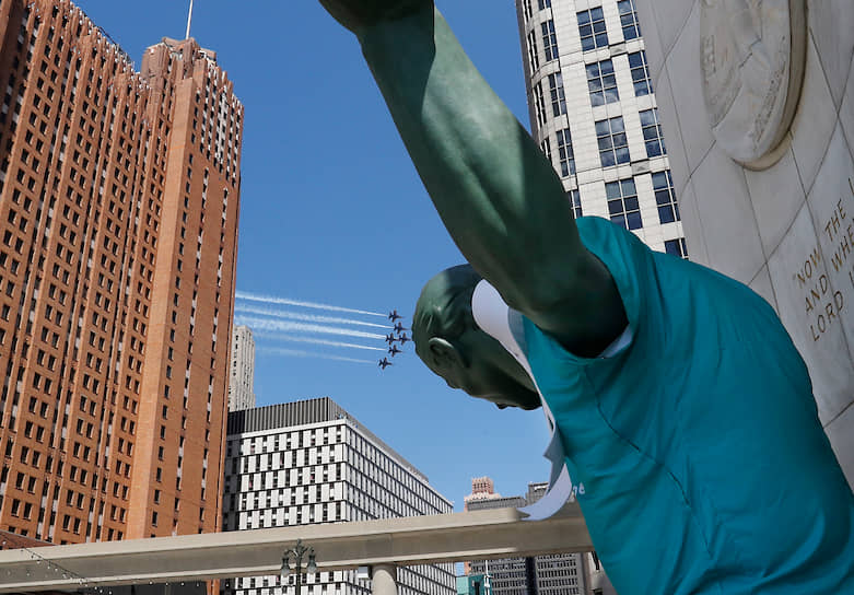 Детройт, США. Статуя «Дух Детройта» с белой лентой, повязанной в честь медицинских работников, на фоне выступления пилотажной группы ВМС «Синие ангелы»
